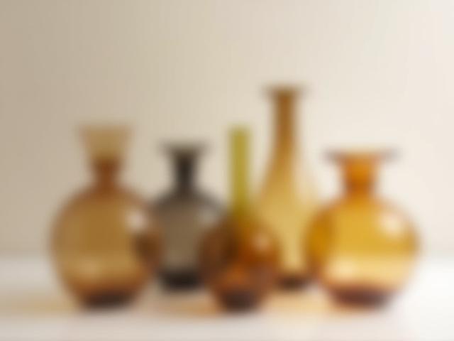 Assortment of handmade blown glass vases in amber and earth tones.